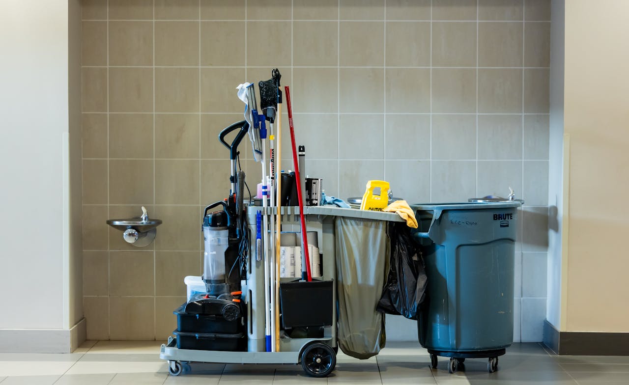 services-02 A comprehensive collection of professional cleaning tools on a cart in an indoor environment.